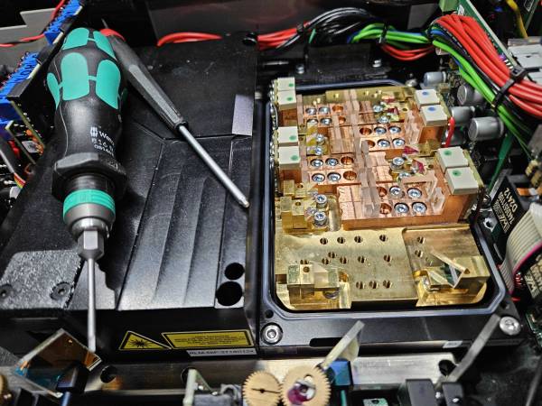 Picture inside a projector with only one module open, and tools sitting on the other module