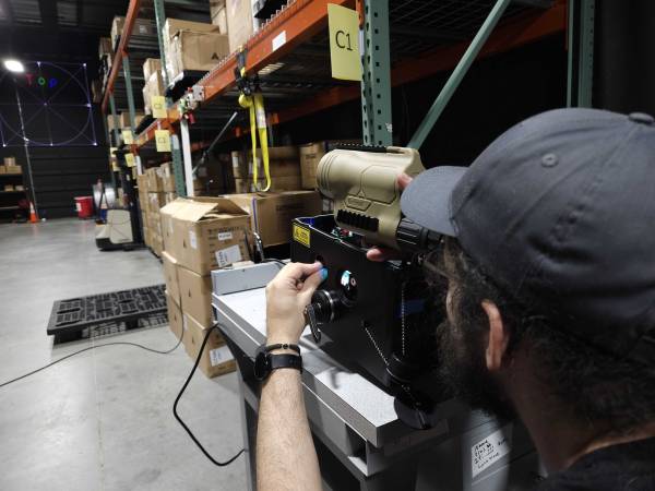 technician looking at a target at distance using spotting scope